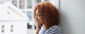 Young woman sitting near a window learns 5 quick tips to improve your credit health