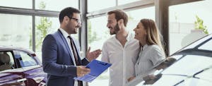 Couple buying a car from salesman.