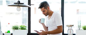 Un hombre mira su teléfono en la cocina