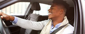 Smiling man driving car that was financed with Acura Financial Services