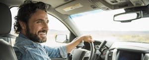 nationwide-auto-insurance-review Man inside car at the wheel smiling
