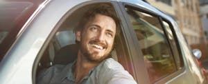Young man looking out of car window