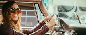 woman driving car and smiling