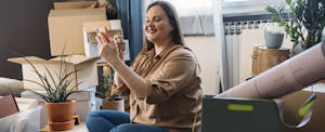 Smiling woman taking a selfie with her new house keys in hand