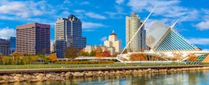 Milwaukee downtown skyline underneath a bright blue sky, with Lake Michigan in the foreground